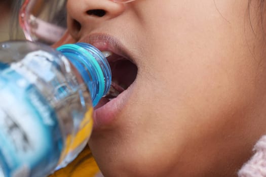 Teenager refreshes with water while enjoying a warm outdoor day.