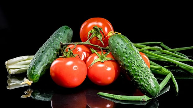 A close-up photo of fresh, ripe tomatoes and cucumbers arranged together, set against a black background, highlighting their vibrant colors and natural textures 
