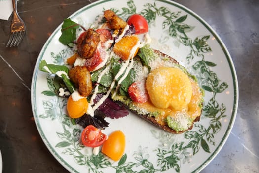 Brunch with avocados, tomatoes, and greens, elegantly served.