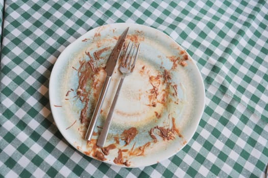 The plate shows remnants of dessert, with utensils resting beside it.