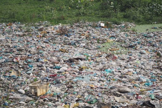 Plastic waste sprawls near water, underscoring pollution issues.