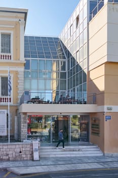 Crete, Greece - April 10, 2025: Main entrance of the Historical Museum of Crete featuring neoclassical architecture and a modern glass facade, with a cultural heritage sign inviting visitors.
