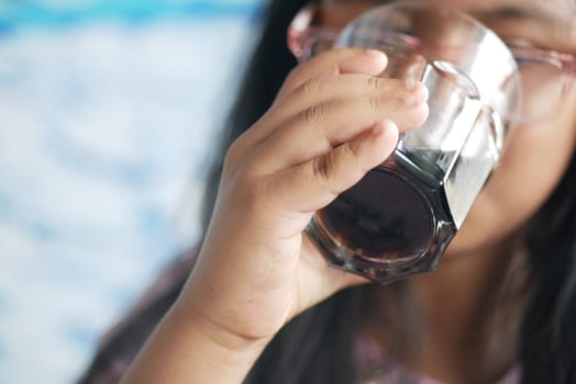 little girl enjoying a refreshing drink on a sunny day.