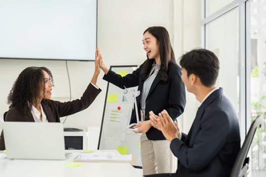 In a cheerful setting, colleagues celebrate their successes in ESG initiatives, highlighting teamwork and positive outcomes.