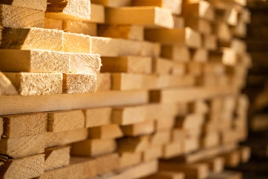 Close up stacks with wooden planks in sawmill storage warehouse. Stack of wood planks for construction in warehouse