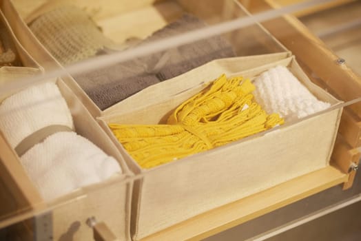 Tidy arrangement of textiles including towels and decorative items in boxes.