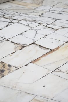 Detailed view of aged marble tiles showcasing intricate patterns and wear.