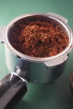 Coffee grounds fill a portafilter waiting for espresso extraction.