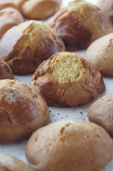 Golden brown bread rolls are arranged neatly, showcasing their textures.