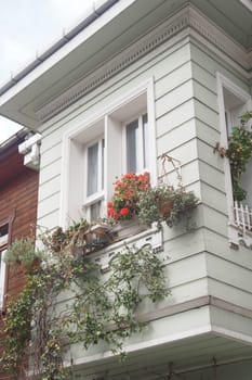Colorful flowers and greenery adorn a charming balcony of a wooden house.