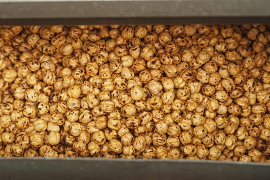 Roasted chickpeas fill a metal container, showcasing their golden brown color.
