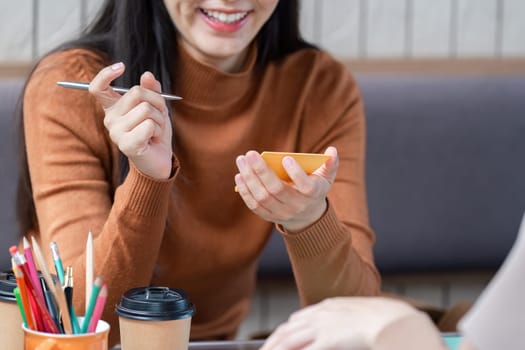 In a lively cafe atmosphere, one student animatedly explains a topic while the other attentively listens, showcasing effective peer learning.