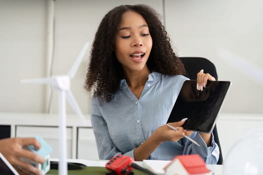 In a dynamic work environment, a dedicated professional engages her audience with creative sustainable project concepts, showcasing innovative practices for a greener future.