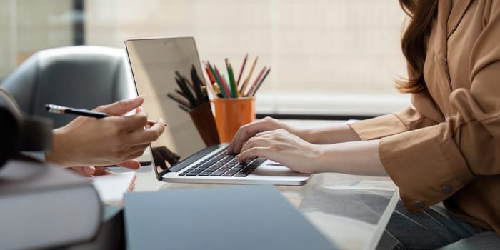 A focused university student engages in a study session, utilizing a laptop and collaborating with peers. The atmosphere highlights concentration and teamwork.
