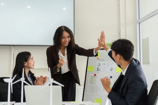 A moment of celebration as team members high-five in recognition of their successful ESG initiatives, embodying teamwork and commitment to sustainability.