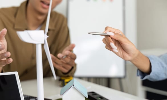 Two experts brainstorm sustainable building strategies, focusing on renewable energy technologies, fostering creativity in a modern office environment.