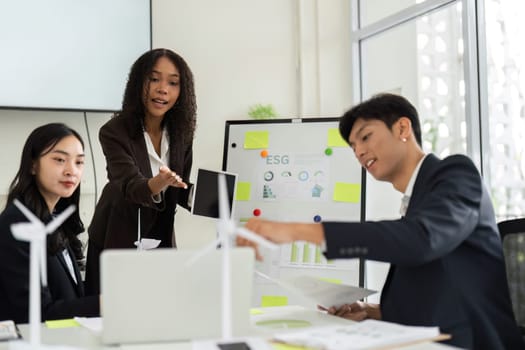 A diverse team collaborates in a conference room, discussing innovative ESG initiatives aimed at enhancing corporate sustainability and eco-friendly practices.