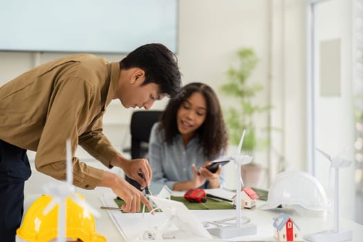 The focus is on a detailed discussion as the man sketches out a sustainable design plan while the woman provides her insights, highlighting teamwork in architecture.