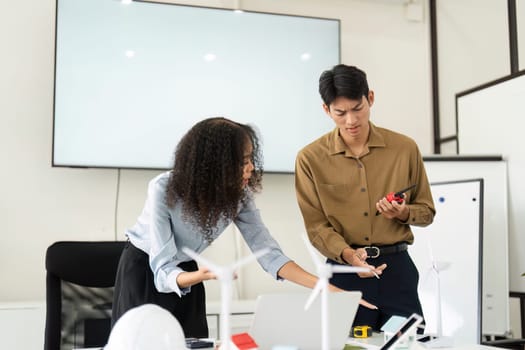A focused discussion between two colleagues about potential renewable energy projects in a modern workspace, emphasizing professional collaboration.