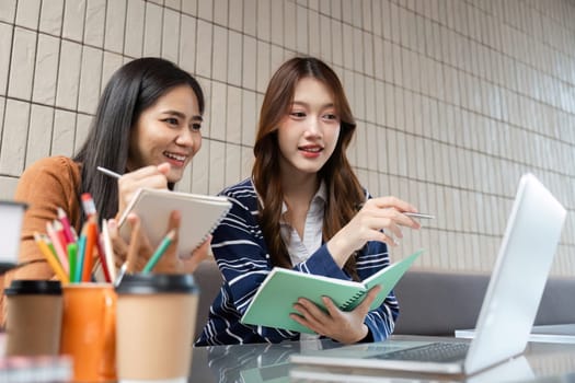 Two students share insights while studying together at a cafe. They enjoy discussing concepts while reviewing their notes and digital resources.