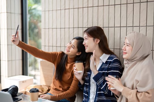 Three friends take a playful selfie together, capturing a joyful moment during their study break and showcasing the strength of their bond.