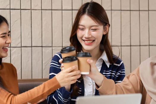 The three friends raise their coffee cups in celebration, capturing a moment of unity and joy as they share a special occasion together.