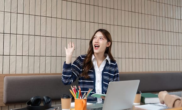 A student enthusiastically participates in her study session, using digital tools to engage with her coursework. The image reflects enthusiasm for learning and academic growth.