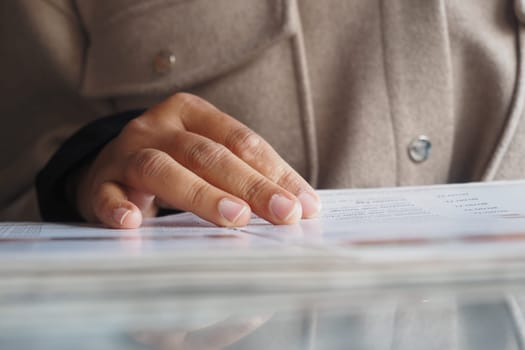 Person's hand rests on a menu, enjoying a moment in a cafe setting.