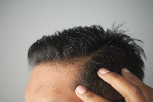 Close-up of a person adjusting their hair for a fresh, neat look.
