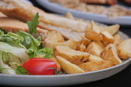 Baked potatoes, fresh salad, and sliced bread arranged beautifully for dinner.
