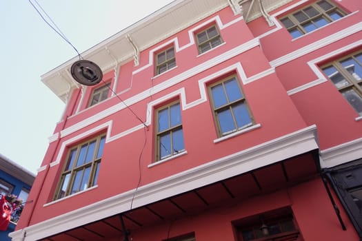 A colorful building features several windows against a bright sky.