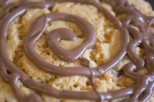 A decadent cookie topped with a rich chocolate swirl design