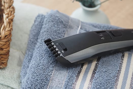 A grooming tool rests on a folded towel during home grooming.