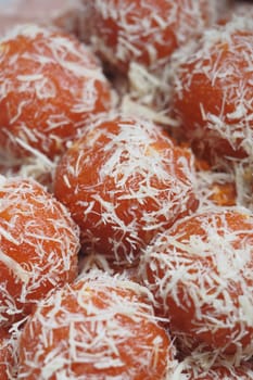 Colorful round sweets coated in shredded coconut attract attention.