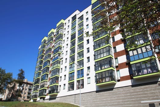 A tall building that features an abundance of windows and several balconies, making it visually striking and attractive for occupants