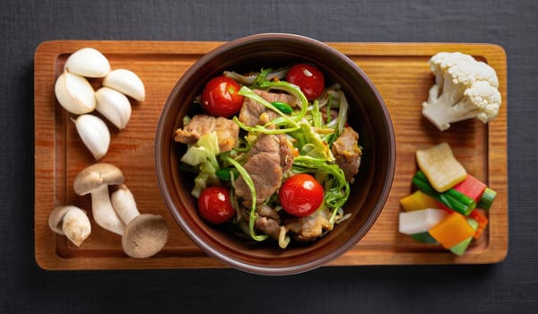 A vibrant stir fry with tender meat, fresh veggies like cabbage and cherry tomatoes, is artfully arranged on a wooden platter with assorted mushrooms and colorful vegetables.