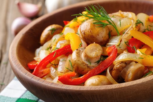 A vibrant stir fry features fresh vegetables and mushrooms in a wooden bowl. The dish includes bell peppers, onions, and herbs, showcasing bright colors and natural textures.