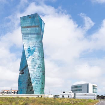 Baku Property Tower, a contemporary skyscraper located in Azerbaijan, boasts a distinctive and asymmetrical design. Its presence stands against a clear blue sky on a sunny spring day