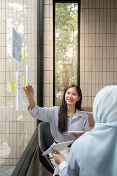 In a bright workspace, two professionals engage in a vibrant discussion about sustainable energy concepts, showcasing models and ideas that highlight environmental stewardship.