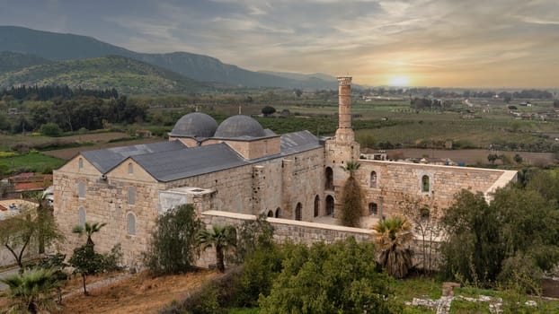 The architectural beauty of Selcuk Isa Bey Mosque during sunset in Selcuk, Izmir, turkey. Surrounding landscapes provide a serene backdrop, enriching the historical significance of the site