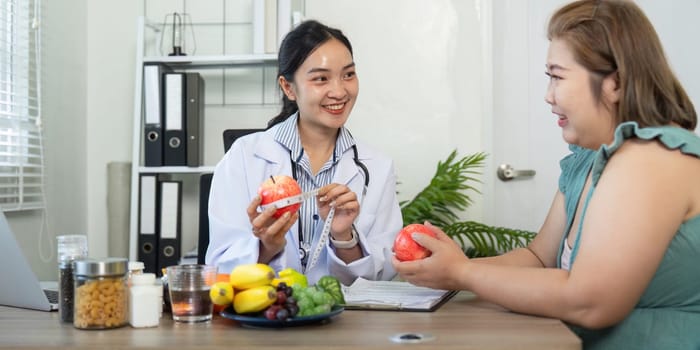 In a supportive consultation, a nutritionist holds apples while explaining their health benefits, engaging her patient in a friendly discussion about nutritious choices.