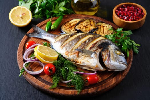 A beautifully arranged platter features freshly grilled fish alongside colorful vegetables and herbs.