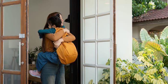 A joyful scene where a mother lifts her daughter in a warm embrace at the door after school, illustrating the cherished family moments filled with love and happiness.