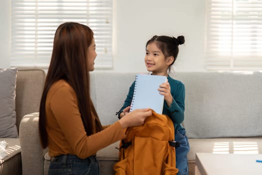 A young girl presents her notebook to her mother, showcasing her excitement for school. This moment reflects the joy of learning and parental support.