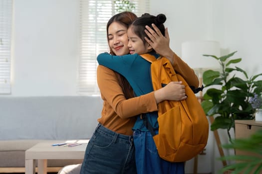 A loving mother embraces her daughter, who is excited for her first day back to school. The image captures the joy of family support and new beginnings.
