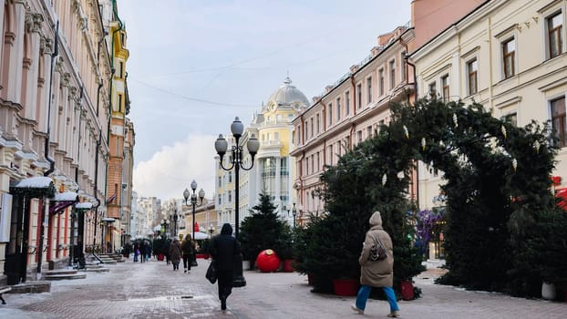 Pedestrians walking on Kuznetsky Most street, decorated for Christmas and New Year holidays, in the historical center of Moscow, Russia