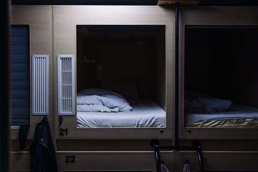 Rows of small, private sleeping pods providing budget-friendly accommodation for travelers seeking a unique and minimalist experience