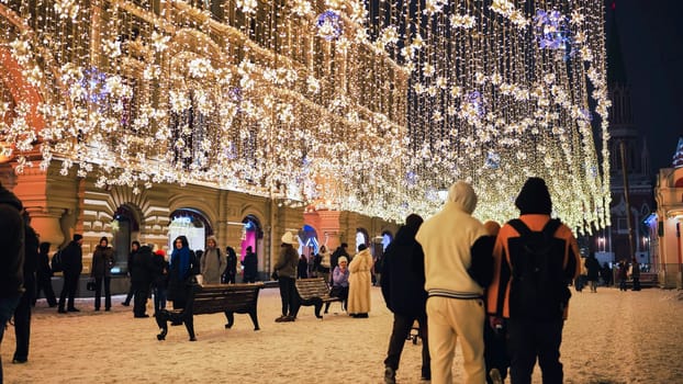 People walking under beautiful Christmas lights in Nikolskaya street in Moscow, Russia