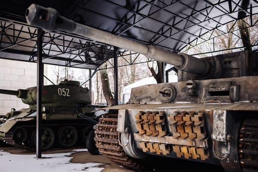 Close-up of a German Tiger I heavy tank and a Soviet T-34-85 medium tank standing in an outdoor museum hangar
