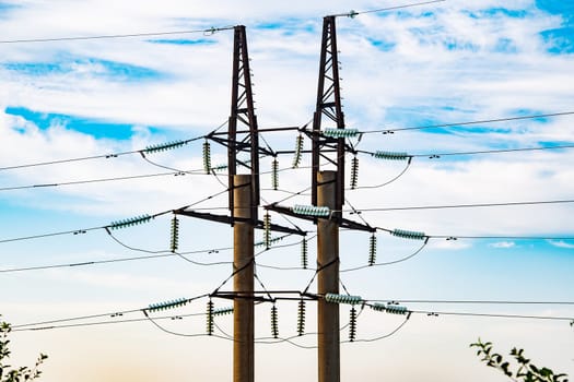Power lines transporting electricity in Crimea, Russia, standing tall against a backdrop of blue sky and white clouds
